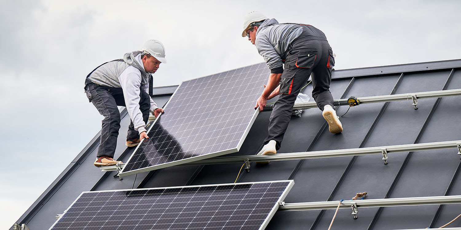 Installers,Installing,Solar,Panel,System,On,Roof,Of,House.,Men