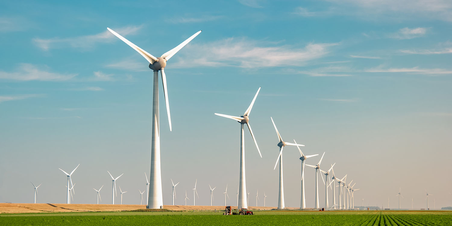 Windmill,Park,With,A,Blue,Sky,And,Green,Agricultural,Field,