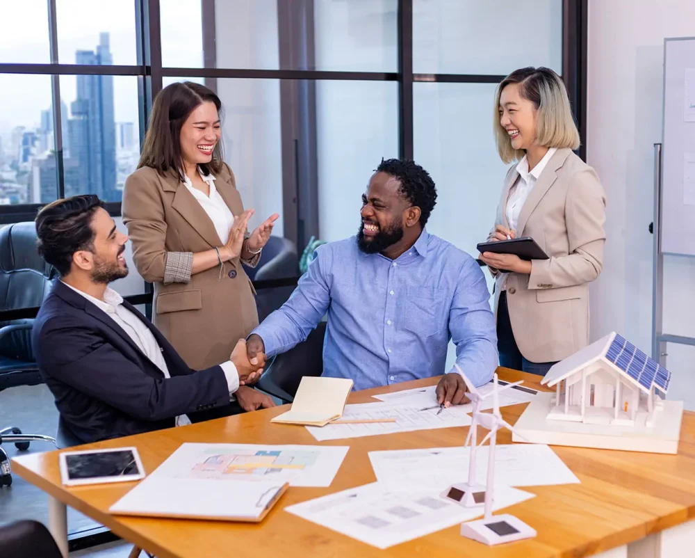 Photo of a team of architects and engineers having handshake and agreement on floor plan over clean energy and power saving house design using solar panel for green industry and futuristic home development